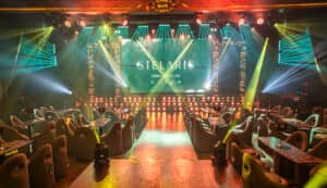 Una discoteca vibrante con luces de escenario coloridas, decoración moderna y cómodos sillones grises es perfecta para eventos o reuniones. Ubicada en uno de los mejores hoteles y resorts de México, sus mesas y efectos de iluminación crean un ambiente animado.